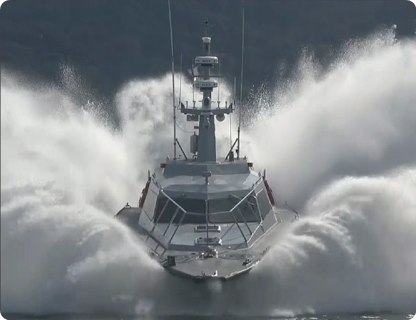 An impactful image of a company building with a prominent logo and fresh landscaping. The setting is bright, capturing a sunny day with blue skies. The camera angle is slightly low to give grandeur to the building, with vivid colors in the signage. Textures of the glass and concrete showcase modern architecture. This visual reinforces our commitment to excellence in engineering solutions.